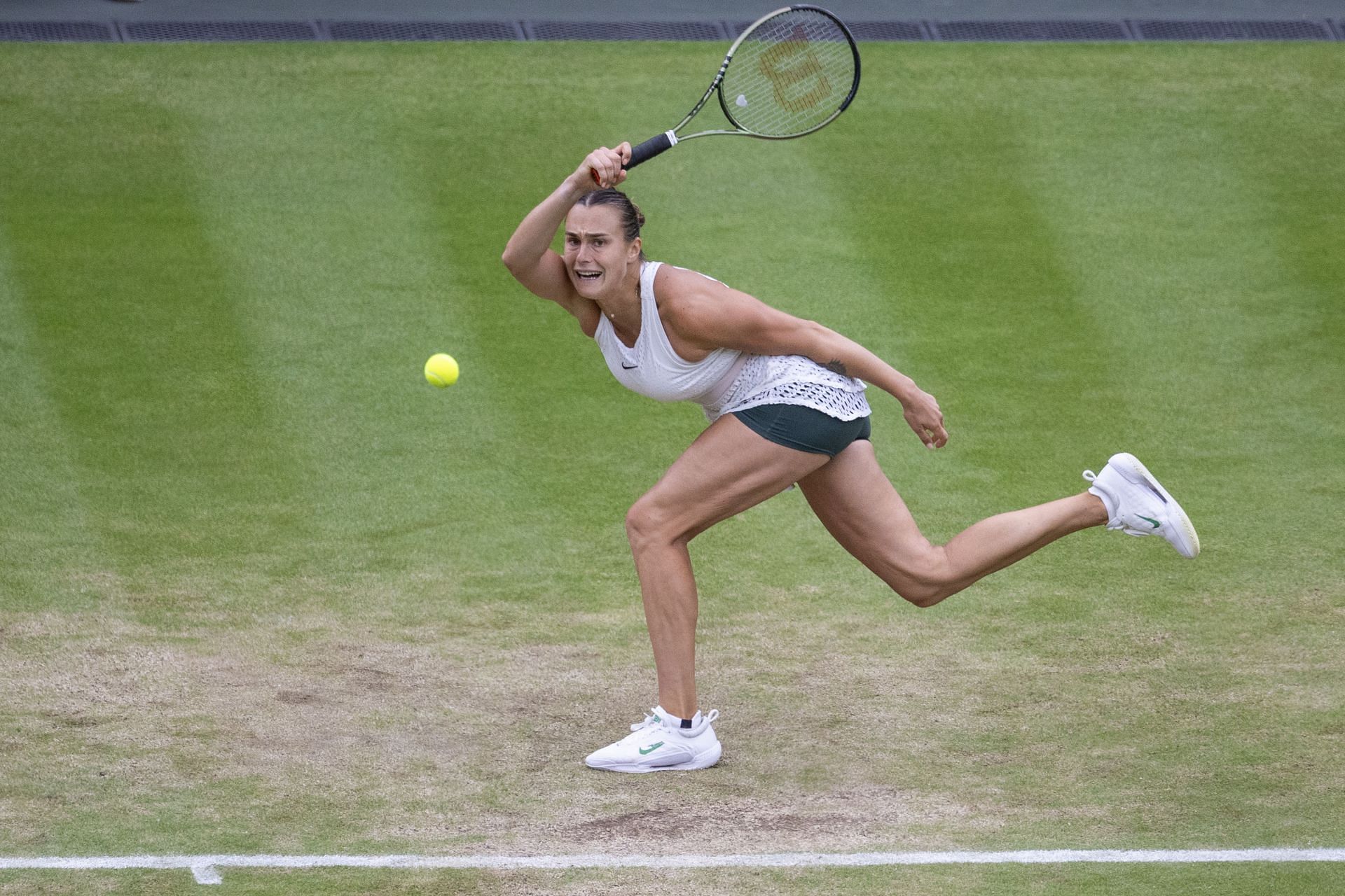 Aryna Sabalenka playing at the 2023 Wimbledon Championships wearing dark green shorts under her all-white tennis dress (Source: Getty)